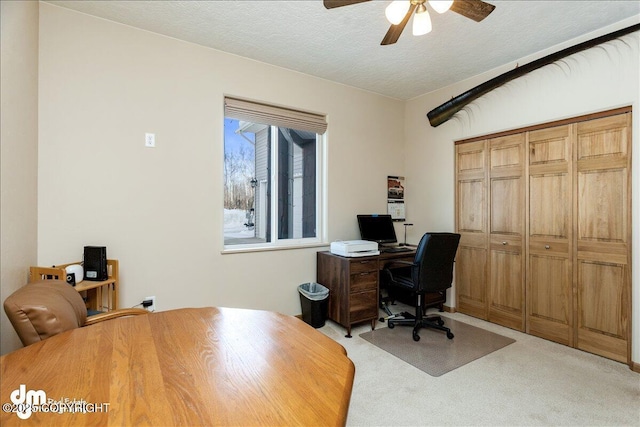 office area with light carpet, a textured ceiling, and a ceiling fan