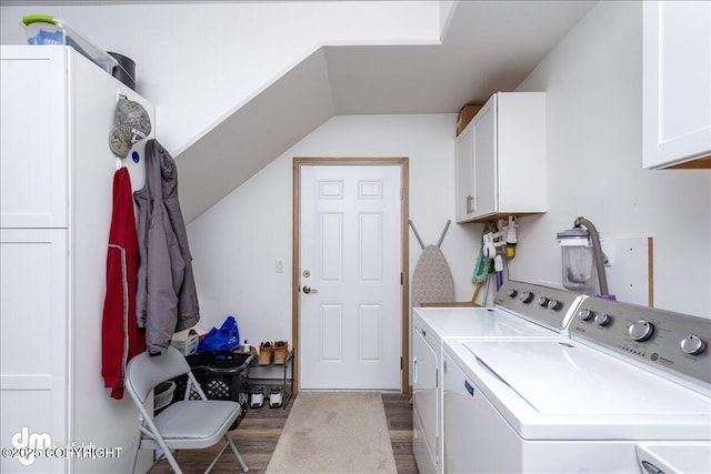 laundry room featuring washer and clothes dryer, wood finished floors, and cabinet space