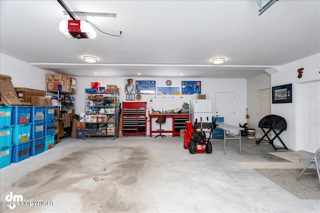 garage with a garage door opener, a workshop area, and freestanding refrigerator