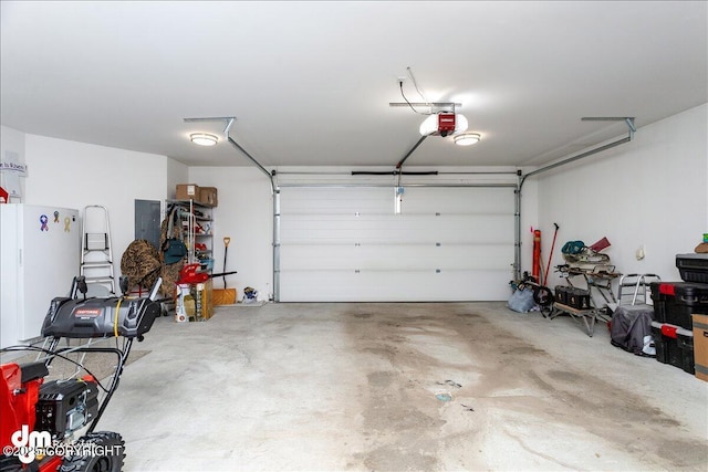 garage featuring freestanding refrigerator and a garage door opener