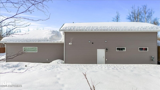 snow covered house featuring metal roof