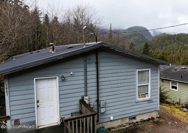 rear view of house with a wooded view