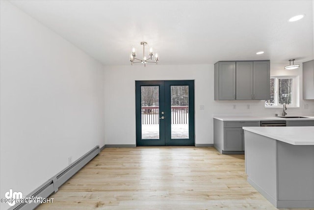 kitchen featuring a baseboard radiator, light wood-style floors, light countertops, french doors, and gray cabinets