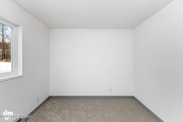 unfurnished room with carpet flooring and baseboards