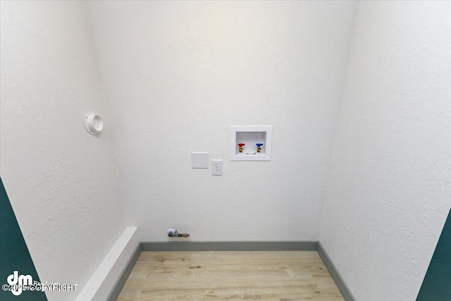 washroom with a textured wall, laundry area, washer hookup, wood finished floors, and baseboards