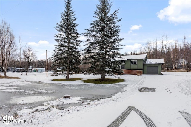 yard covered in snow featuring a garage