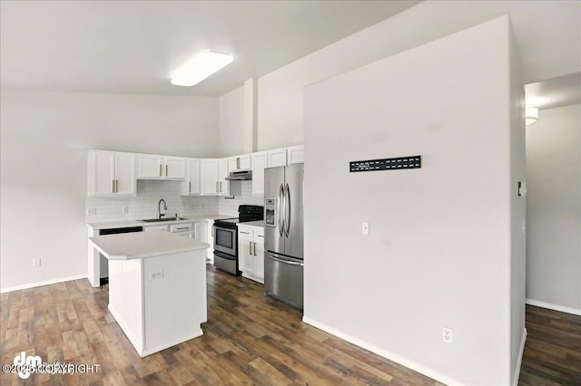 kitchen with stainless steel appliances, a sink, under cabinet range hood, light countertops, and white cabinets