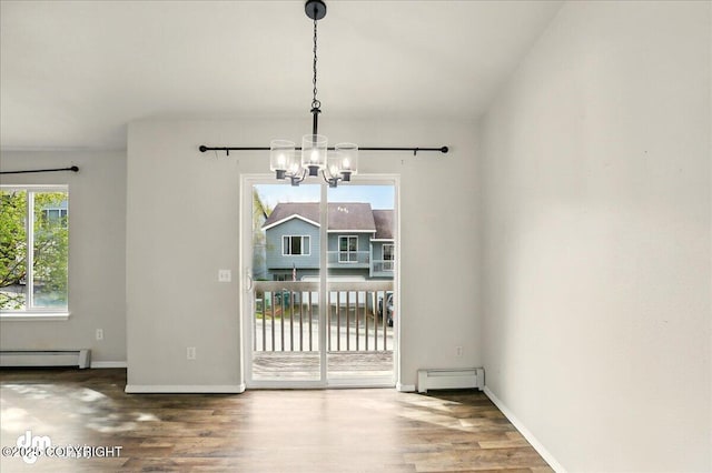 unfurnished dining area with a chandelier, baseboard heating, a baseboard heating unit, and wood finished floors