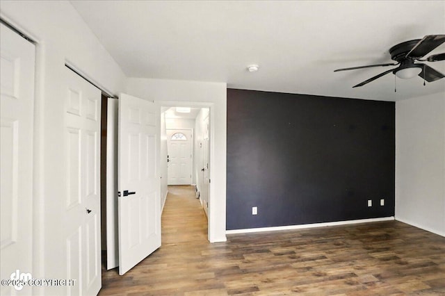 unfurnished bedroom with wood finished floors, a closet, and baseboards