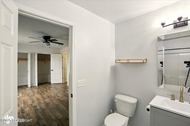 bathroom featuring wood finished floors, a ceiling fan, vanity, and toilet