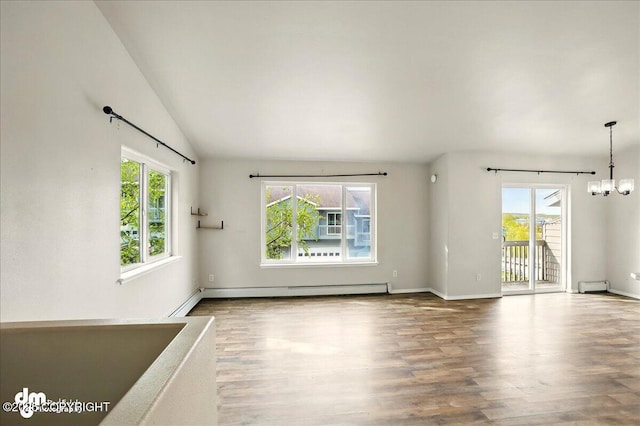spare room with healthy amount of natural light, wood finished floors, baseboard heating, a chandelier, and lofted ceiling