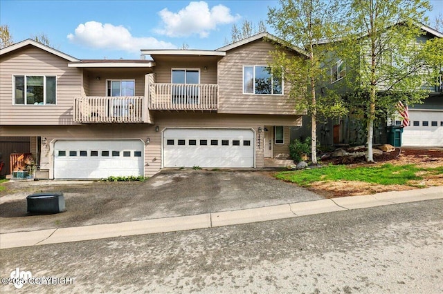 view of front of home with a balcony, driveway, and a garage
