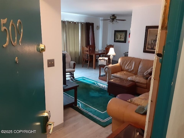 living room with a ceiling fan and light wood finished floors