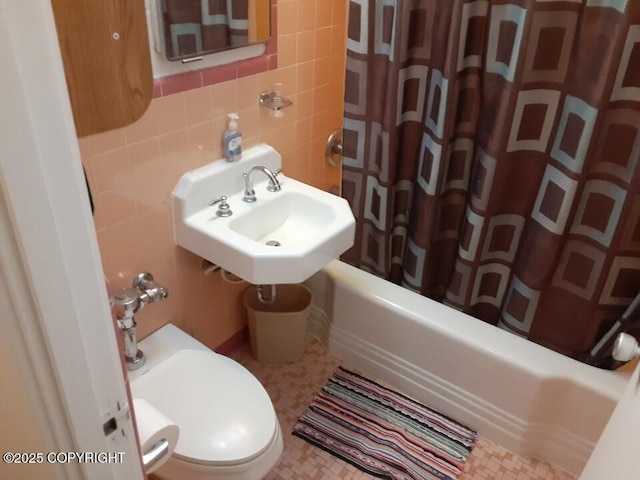 full bathroom featuring tile walls, toilet, backsplash, shower / bath combination with curtain, and a sink