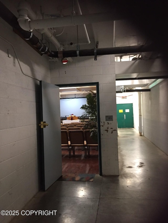 hall with finished concrete floors and concrete block wall