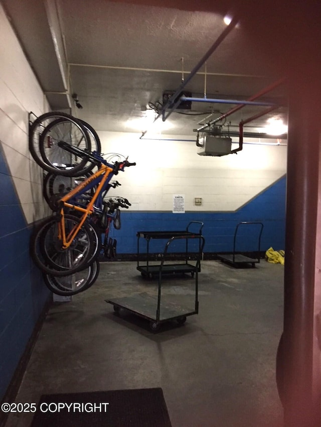 garage featuring concrete block wall and a garage door opener