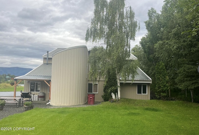 3151 E Cottle Loop, Wasilla, AK 99654 - back of property with a lawn, metal roof, and a patio