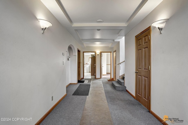 hallway with washer / dryer, baseboards, arched walkways, stairway, and carpet floors