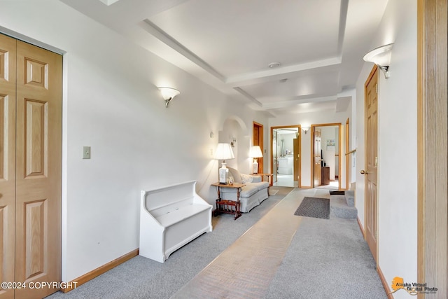 interior space with beam ceiling, light carpet, and baseboards