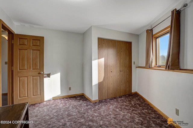 unfurnished bedroom featuring a closet, carpet flooring, and baseboards