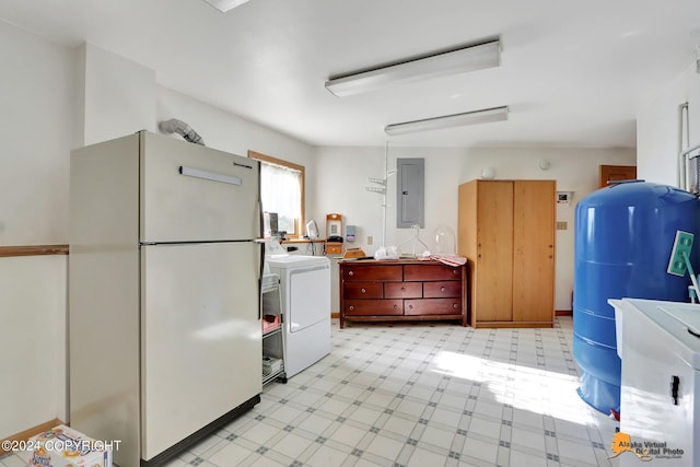 kitchen with light floors, light countertops, freestanding refrigerator, washer / dryer, and electric panel