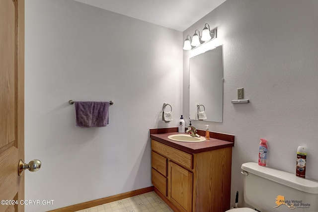 bathroom with baseboards, vanity, toilet, and tile patterned floors