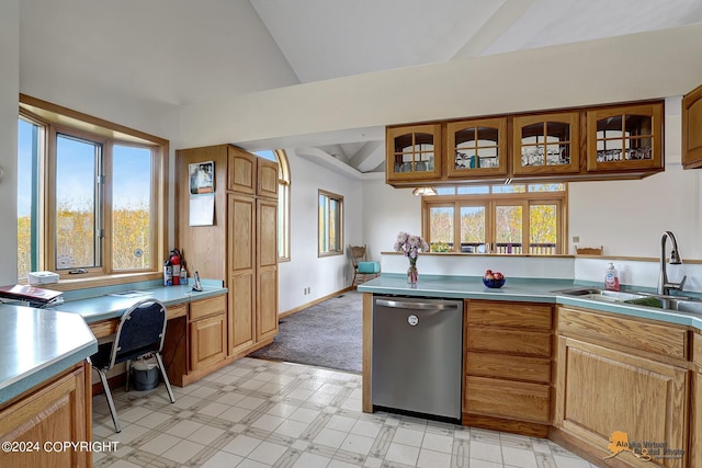 kitchen featuring dishwasher, glass insert cabinets, light countertops, built in desk, and a sink