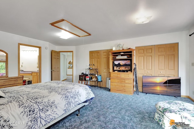 bedroom featuring attic access, carpet, multiple closets, and ensuite bathroom