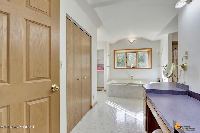 full bath with vaulted ceiling, a bath, and vanity