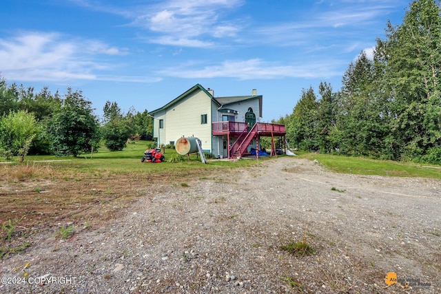 view of front facade featuring stairs, a deck, and a chimney