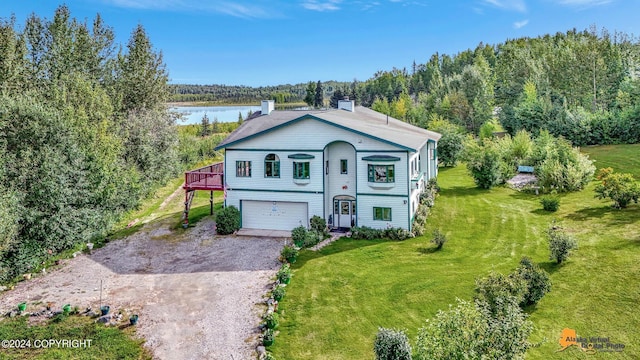 view of front of home featuring an attached garage, a deck with water view, dirt driveway, a chimney, and a front yard