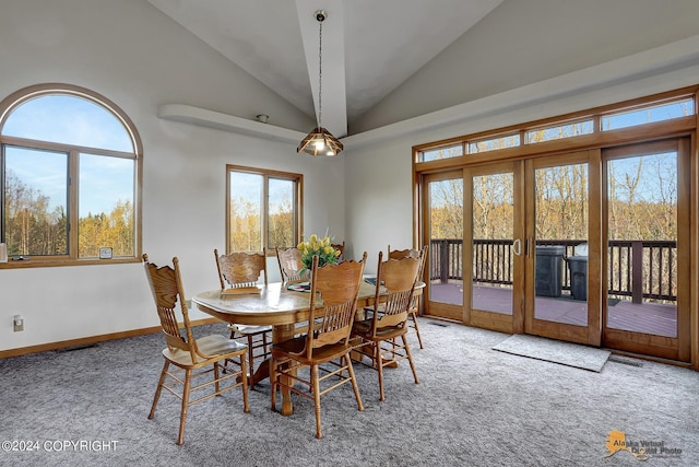 carpeted dining area featuring high vaulted ceiling, french doors, and baseboards