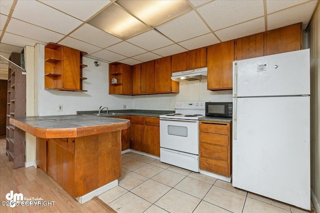 541 E 22nd Ave, Anchorage, AK 99503 - kitchen with white appliances, under cabinet range hood, open shelves, brown cabinets, and a paneled ceiling