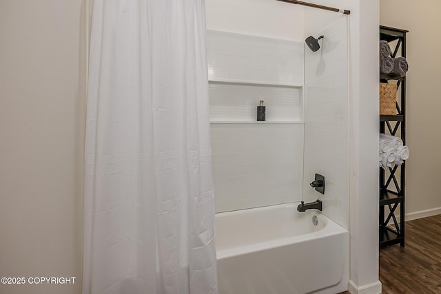 bathroom featuring shower / tub combo, baseboards, and wood finished floors