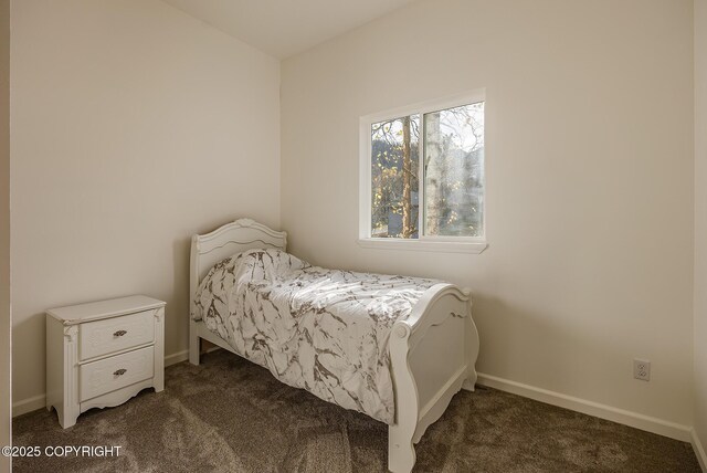 bedroom featuring dark colored carpet and baseboards