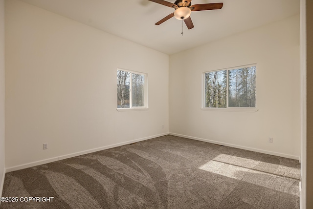 carpeted empty room with ceiling fan and baseboards
