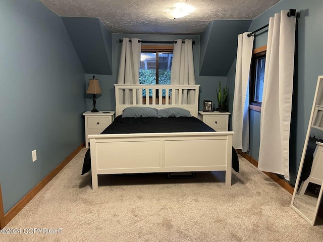 bedroom featuring light carpet, vaulted ceiling, a textured ceiling, and baseboards