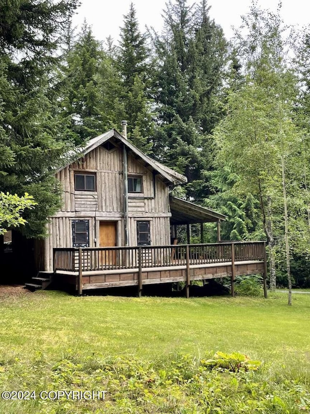 rear view of house featuring a yard and a wooden deck