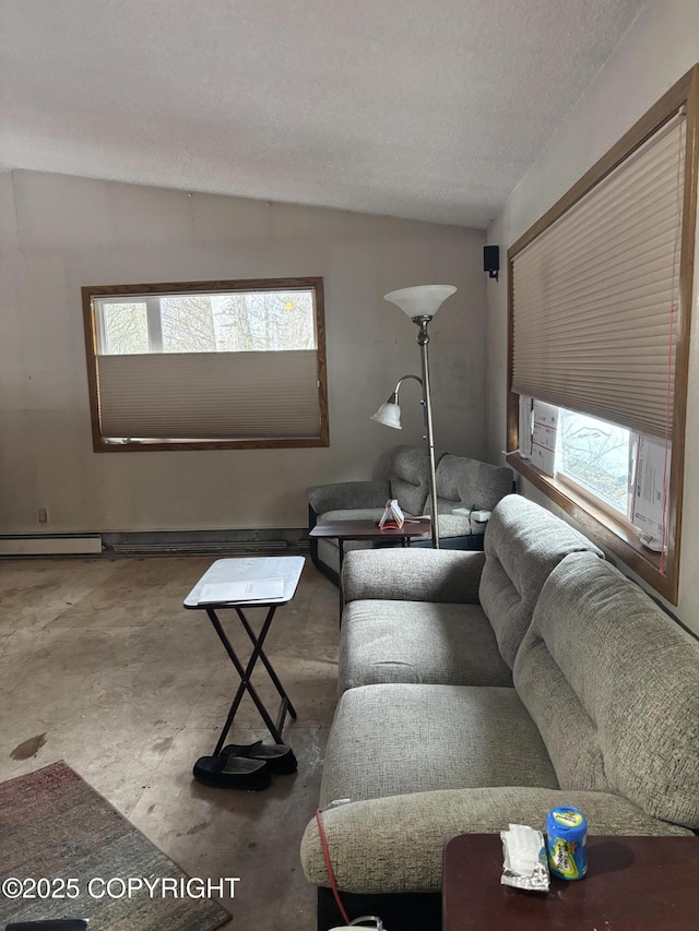 living area with vaulted ceiling, plenty of natural light, concrete flooring, and a baseboard radiator