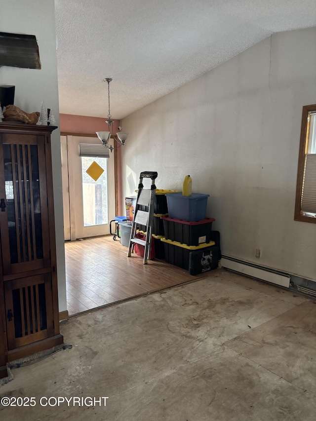 dining room featuring a textured ceiling, concrete flooring, a baseboard radiator, and a chandelier