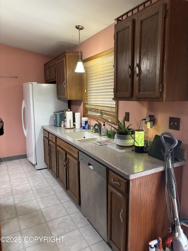 kitchen featuring stainless steel dishwasher, a sink, decorative light fixtures, vaulted ceiling, and dark brown cabinetry