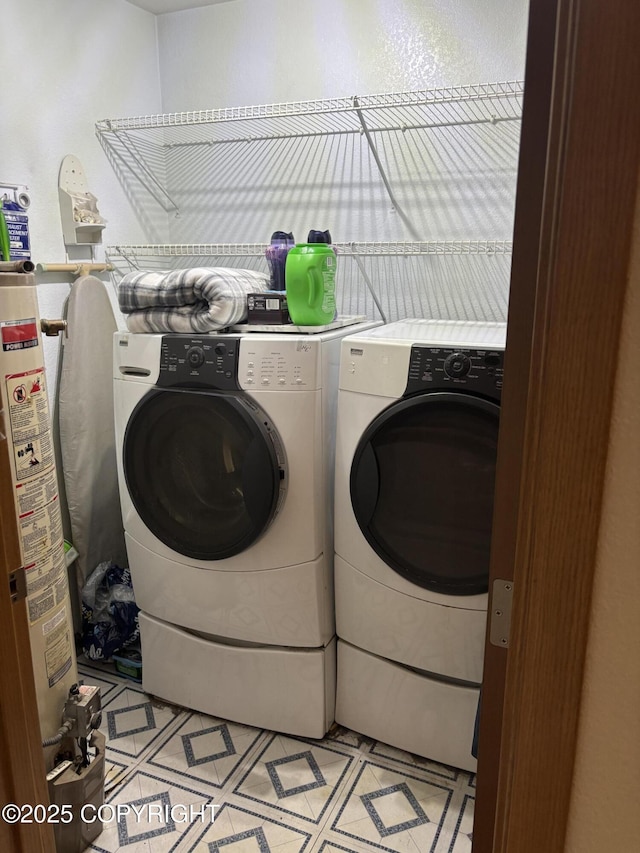 laundry area with washer and clothes dryer and water heater