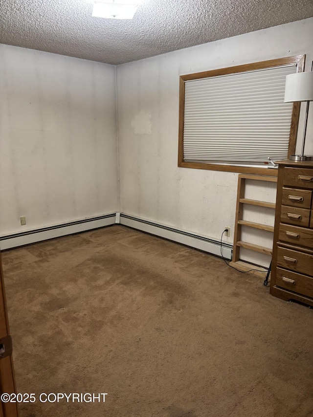 carpeted spare room with a textured ceiling and a baseboard heating unit