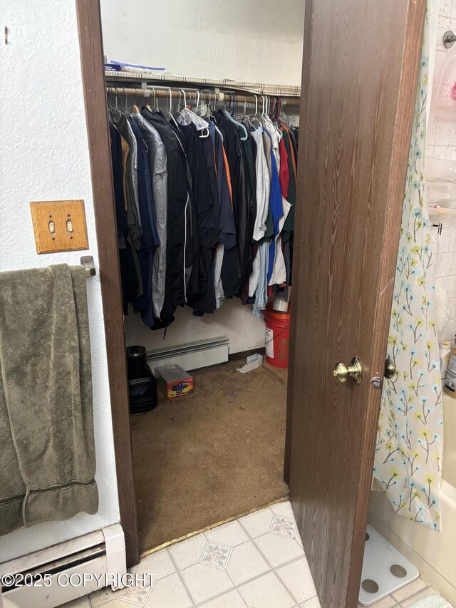 walk in closet with a baseboard heating unit and carpet floors