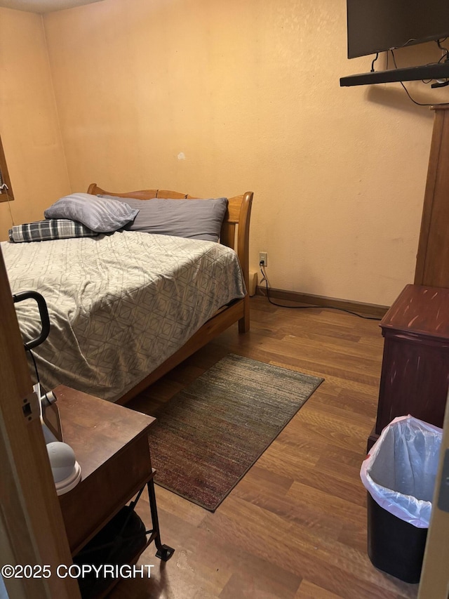 bedroom with wood finished floors and baseboards