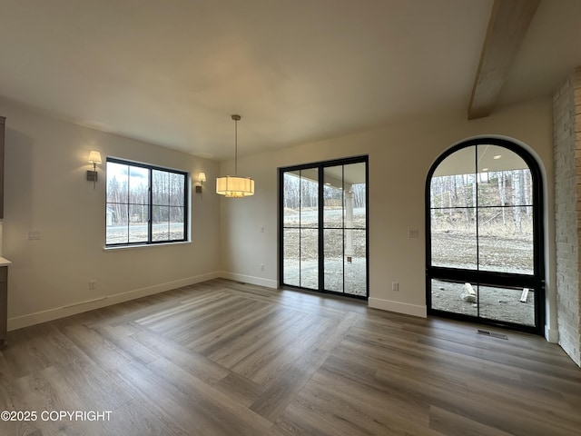 unfurnished dining area with dark wood-type flooring, visible vents, and baseboards