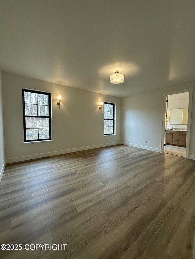 empty room featuring wood finished floors and baseboards