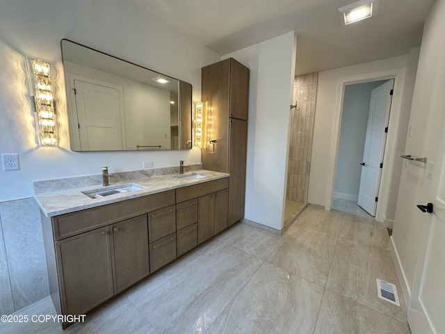 full bath featuring a walk in shower, a sink, visible vents, and double vanity