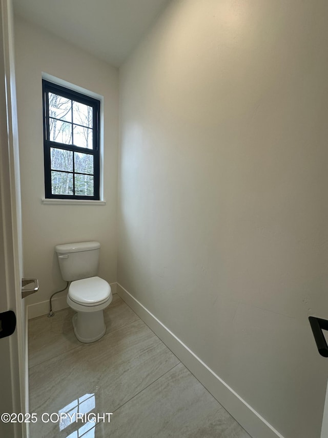bathroom with baseboards and toilet