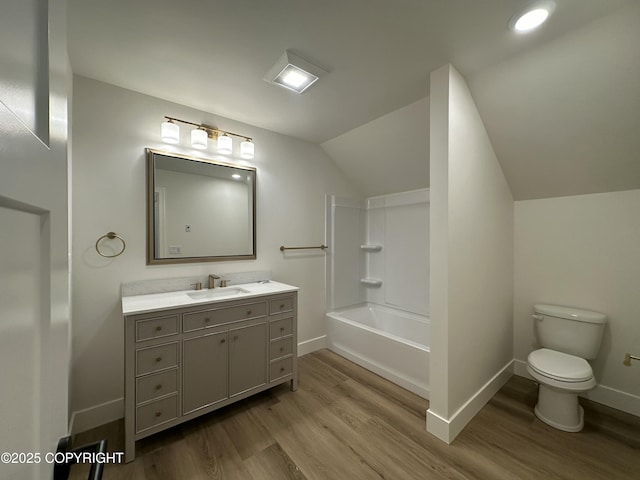 full bathroom featuring vaulted ceiling, wood finished floors, toilet, vanity, and baseboards